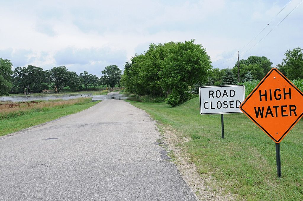 FEMA photographed warning signs at a flooded Wisconsin road. This archived scene illustrates a closure, not current conditions or a crossing demonstration.